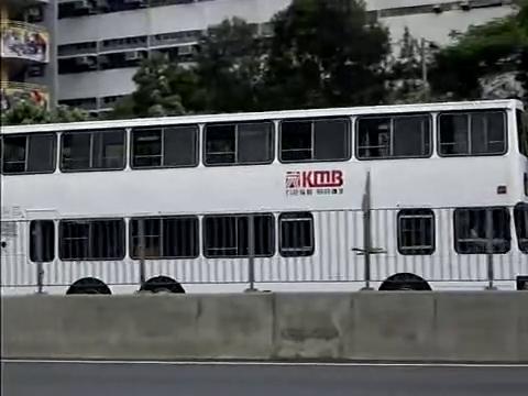 A white double-decker bus travelling along a highway.